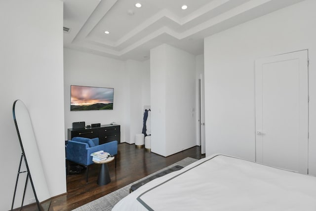 bedroom with a tray ceiling and dark hardwood / wood-style floors