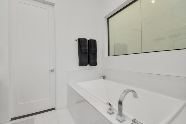 bathroom featuring tile patterned flooring and tiled tub