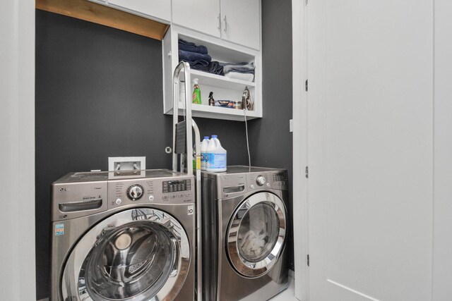 clothes washing area with cabinets and independent washer and dryer