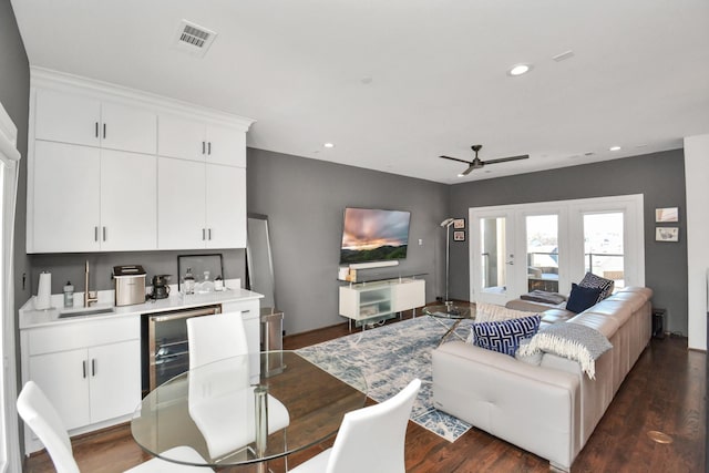 dining area with indoor wet bar, dark wood-type flooring, beverage cooler, and ceiling fan