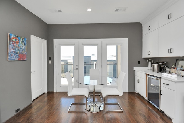 dining room with dark wood-type flooring, sink, wine cooler, and french doors