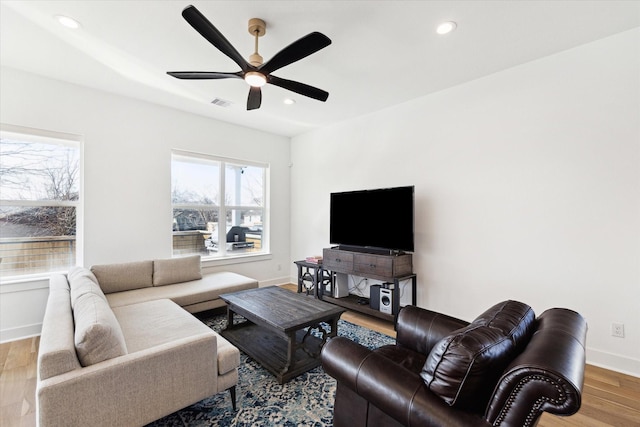 living room with ceiling fan and light hardwood / wood-style flooring