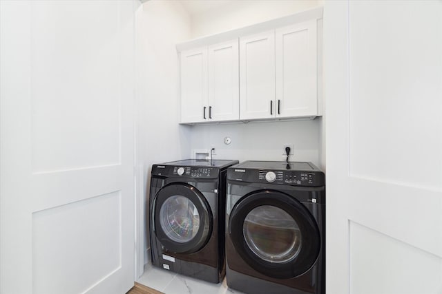 laundry room featuring cabinets and washer and dryer