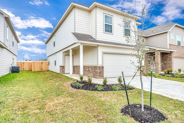 view of front of property featuring a garage, a front yard, and central air condition unit