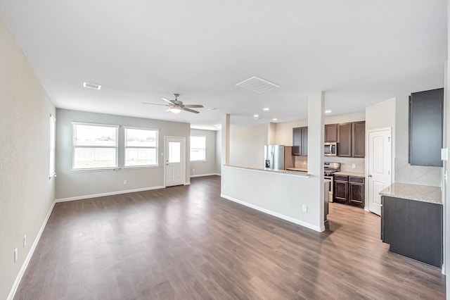 unfurnished living room featuring dark wood-type flooring and ceiling fan