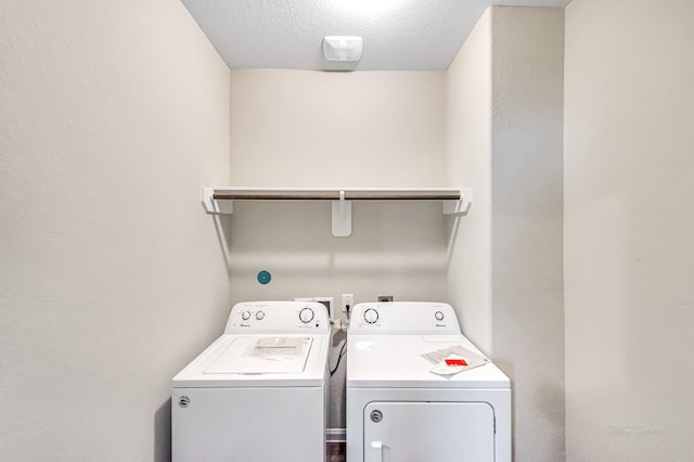 laundry room featuring separate washer and dryer and a textured ceiling