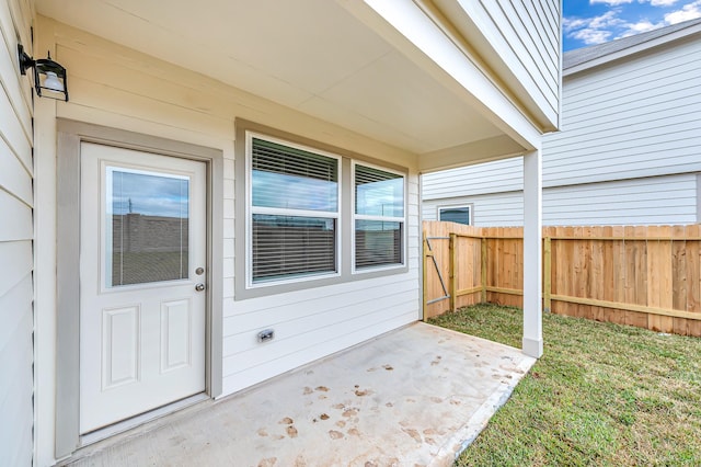 view of exterior entry with a patio area