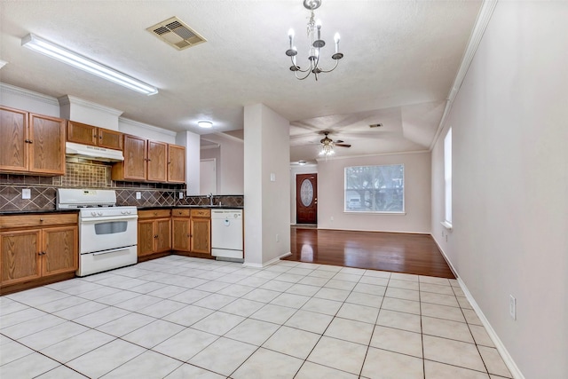 kitchen featuring crown molding, white appliances, ceiling fan with notable chandelier, and backsplash