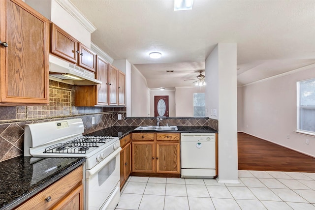 kitchen featuring light tile patterned flooring, sink, backsplash, and white appliances