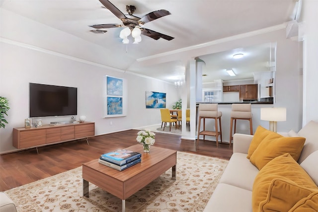 living room with crown molding, ceiling fan with notable chandelier, and hardwood / wood-style flooring