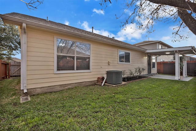 back of property with central AC unit, a yard, and a patio area