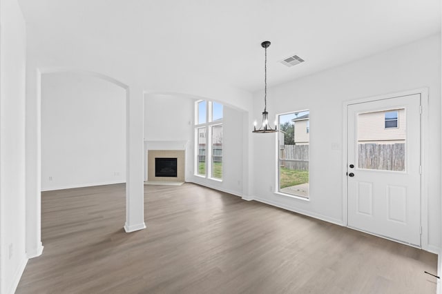 unfurnished dining area featuring a notable chandelier and hardwood / wood-style flooring