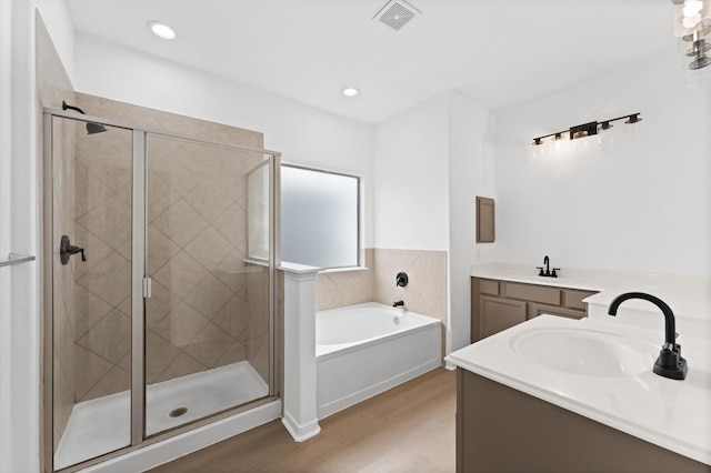 bathroom featuring vanity, independent shower and bath, and wood-type flooring