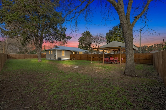 yard at dusk with a gazebo and central AC