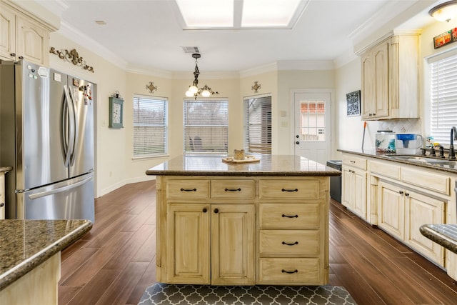 125 Indian Warrior Trl, Lake Jackson, TX 77566 - kitchen with pendant lighting, light brown cabinetry, sink, stainless steel fridge, and dark wood-type flooring