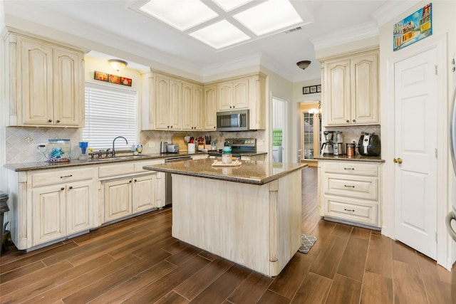 125 Indian Warrior Trl, Lake Jackson, TX 77566 - kitchen with sink, crown molding, a center island, dark stone countertops, and stainless steel appliances