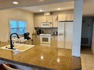 kitchen with white cabinets, white appliances, and kitchen peninsula