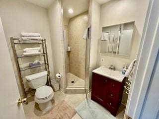 bathroom with an enclosed shower, vanity, and toilet