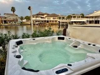 view of pool featuring a hot tub and a water view