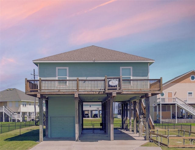 view of front facade with a yard, a garage, a carport, and a balcony