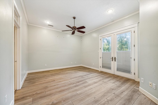 empty room with ornamental molding, light wood-type flooring, and french doors