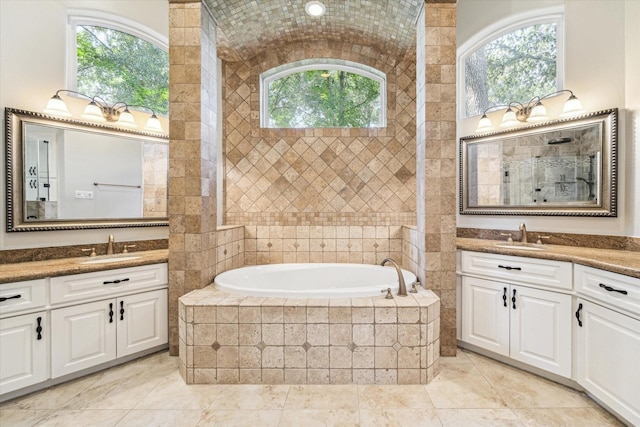 bathroom featuring tiled tub and vanity