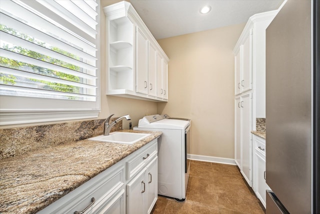 laundry area with cabinets, separate washer and dryer, and sink