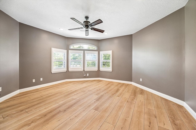 spare room with ceiling fan, light hardwood / wood-style flooring, and a textured ceiling