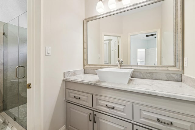 bathroom with a shower with door and vanity