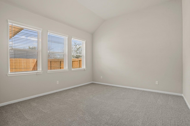 carpeted empty room with lofted ceiling