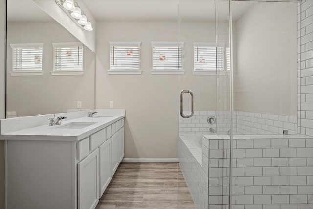 bathroom featuring vanity, hardwood / wood-style flooring, and plus walk in shower