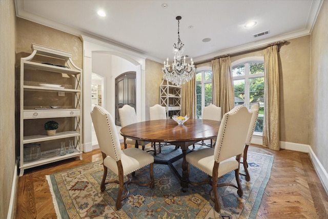 dining area featuring a notable chandelier, ornamental molding, and dark parquet floors