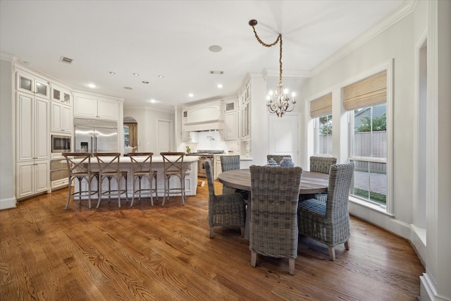 dining area with dark hardwood / wood-style flooring, crown molding, and a chandelier