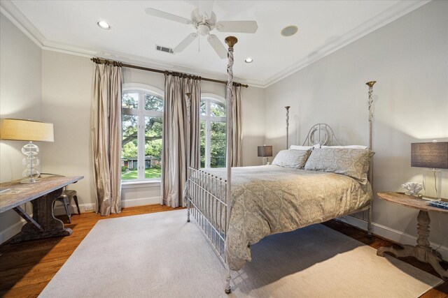 bedroom with hardwood / wood-style flooring, ceiling fan, and ornamental molding