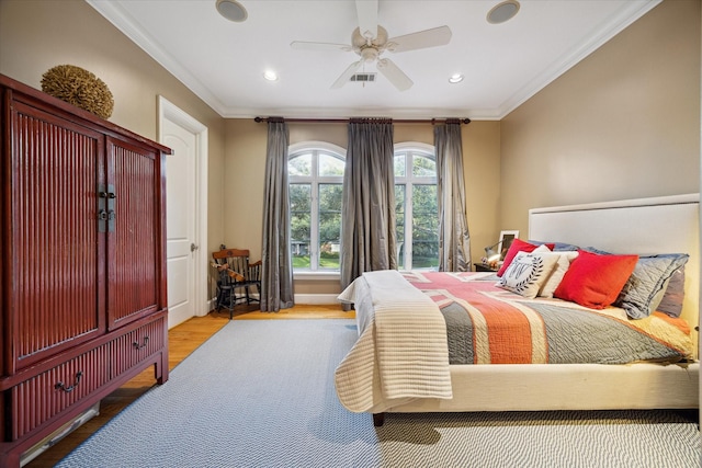 bedroom featuring ornamental molding, ceiling fan, and light hardwood / wood-style flooring