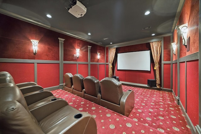 carpeted home theater room featuring crown molding