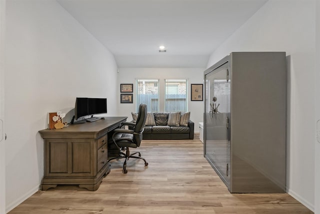 office featuring lofted ceiling and light hardwood / wood-style flooring