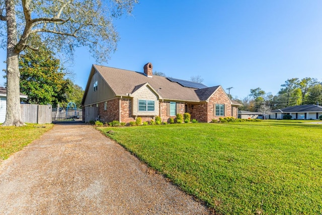 view of front of house featuring a front lawn and solar panels