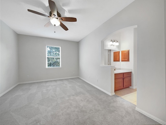 carpeted spare room with sink and ceiling fan