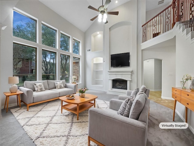 living room with a high ceiling and ceiling fan