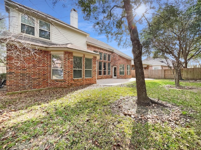 rear view of property featuring a yard and a patio area