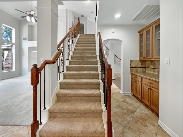 stairs with tile patterned flooring and ceiling fan