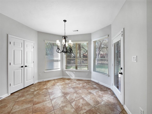 unfurnished dining area featuring light tile patterned floors and a notable chandelier