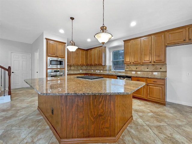 kitchen featuring light stone countertops, appliances with stainless steel finishes, sink, and a spacious island