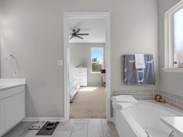 bathroom featuring vanity, ceiling fan, and a tub to relax in