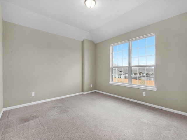 empty room featuring carpet floors and vaulted ceiling