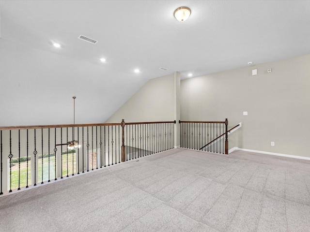 carpeted spare room with lofted ceiling