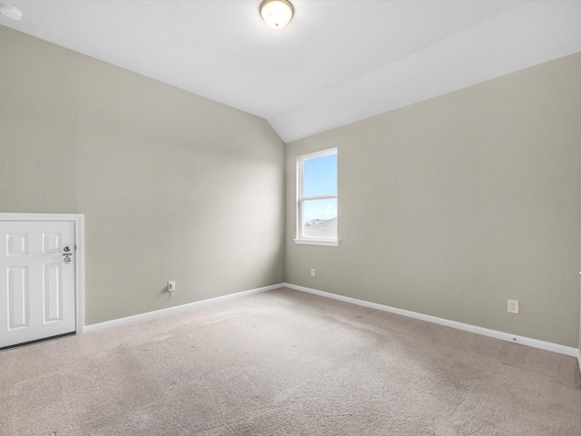 empty room with lofted ceiling and carpet floors