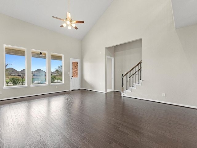 unfurnished living room with ceiling fan, dark hardwood / wood-style floors, and high vaulted ceiling