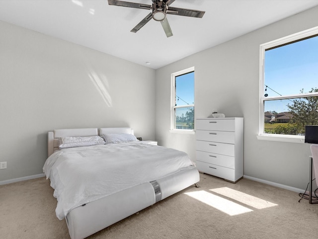 carpeted bedroom with ceiling fan and multiple windows